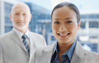 a woman and a man, both smiling and wearing grey suits